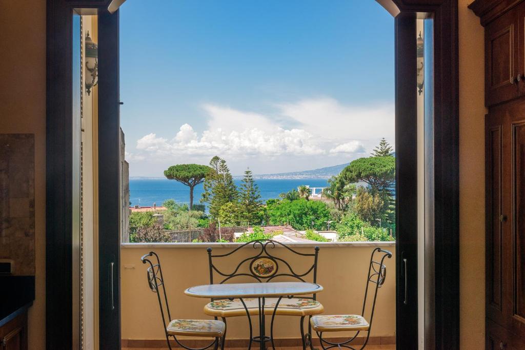 uma mesa e cadeiras numa varanda com vista para o oceano em Casa Rajada Sorrento em Sorrento