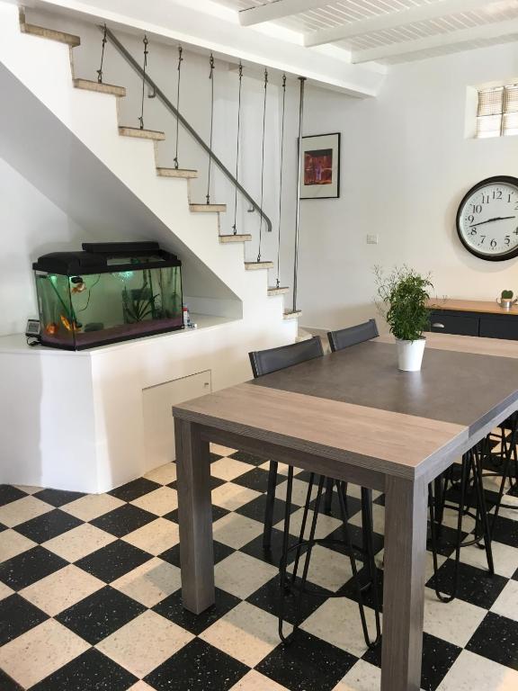 une salle à manger avec une table et un aquarium dans l'établissement Maison de village, à Velleron