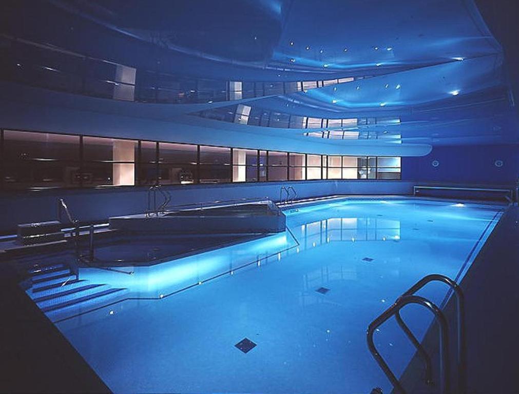 a large swimming pool with blue lights in a building at Whoop Hall Hotel and Leisure in Kirkby Lonsdale