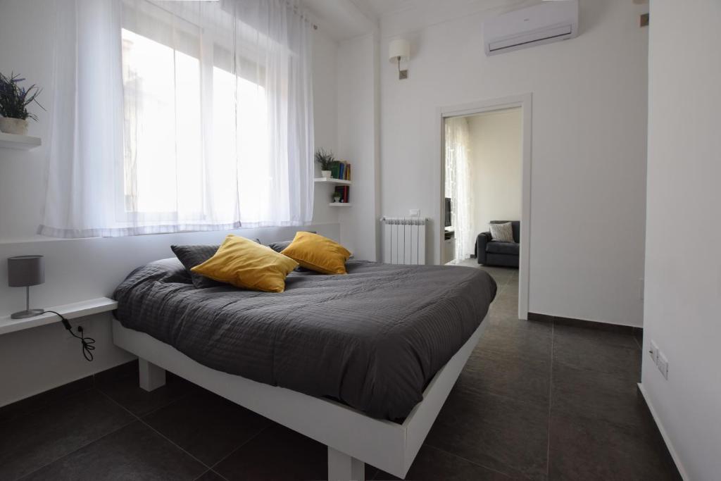 um quarto com uma cama com duas almofadas amarelas em Teatro Massimo Cool Home em Palermo