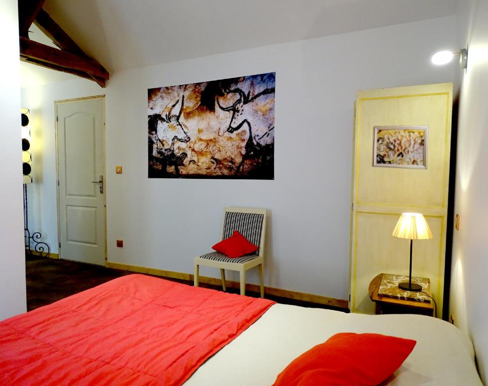 ドンムにあるChambre Lascaux aux Meulieres a Dommeのベッドルーム(赤いベッド1台、椅子付)