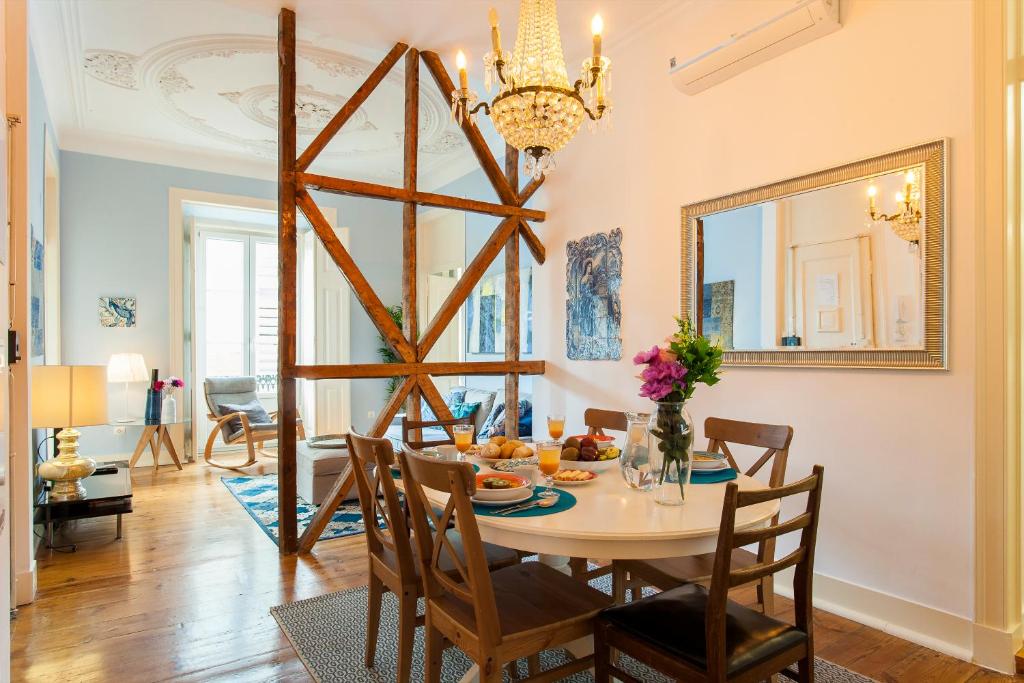 une salle à manger avec une table et un lustre dans l'établissement Bairro Alto 3 Bedroom Patio Flat!, à Lisbonne