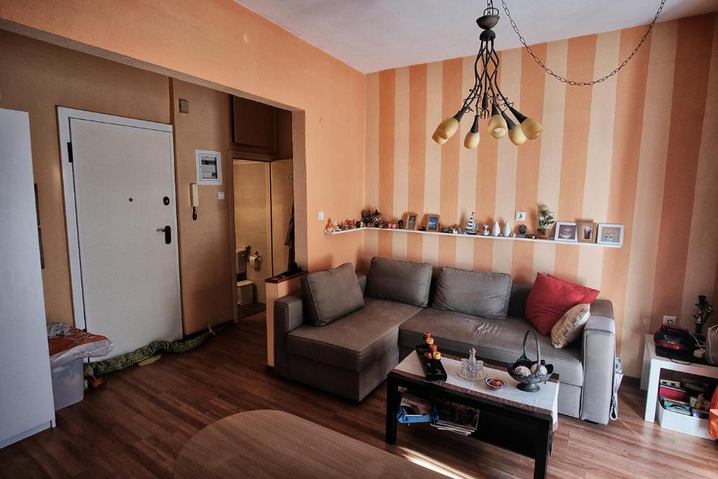 ein Wohnzimmer mit einem Sofa und einem Tisch in der Unterkunft Ioanna Studio in Peraia