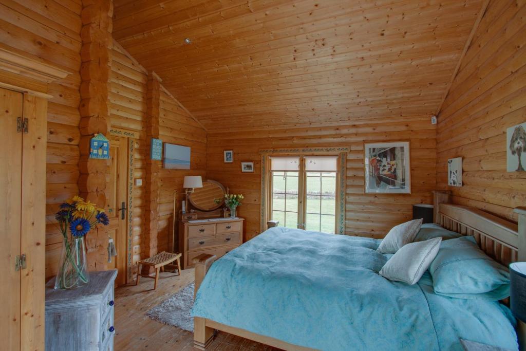 um quarto com uma cama num chalé de madeira em Balnabrechan Lodge em Arbroath