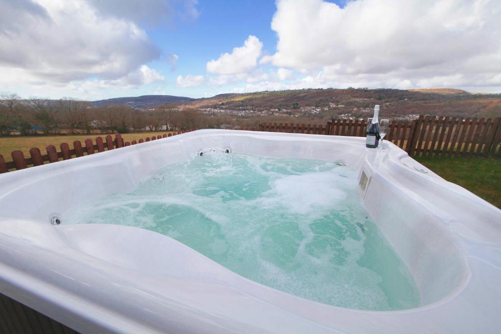a jacuzzi tub in a backyard with at Cilhendre Holiday Cottages - The Dairy in Swansea