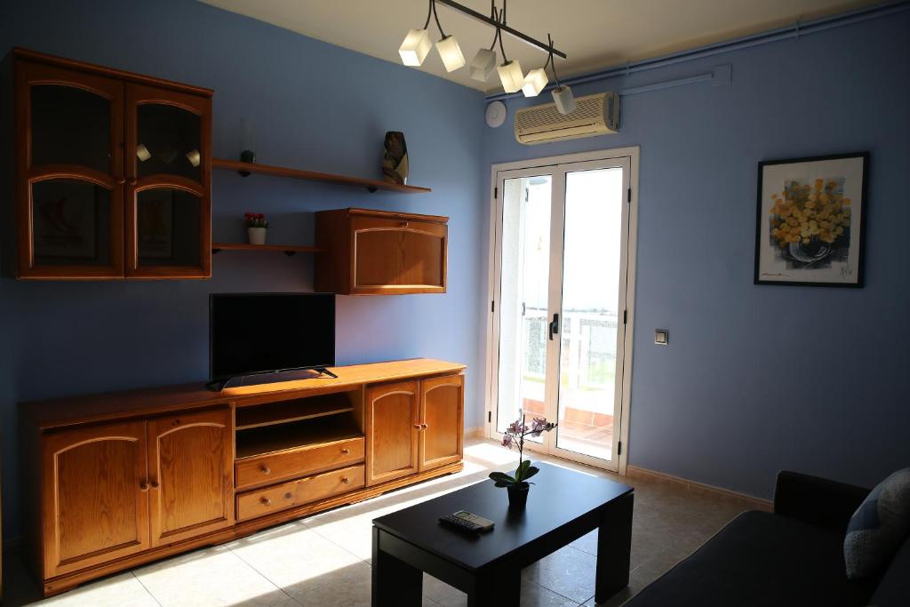 a living room with a tv on a wooden entertainment center at Villa hortencia in Tarragona