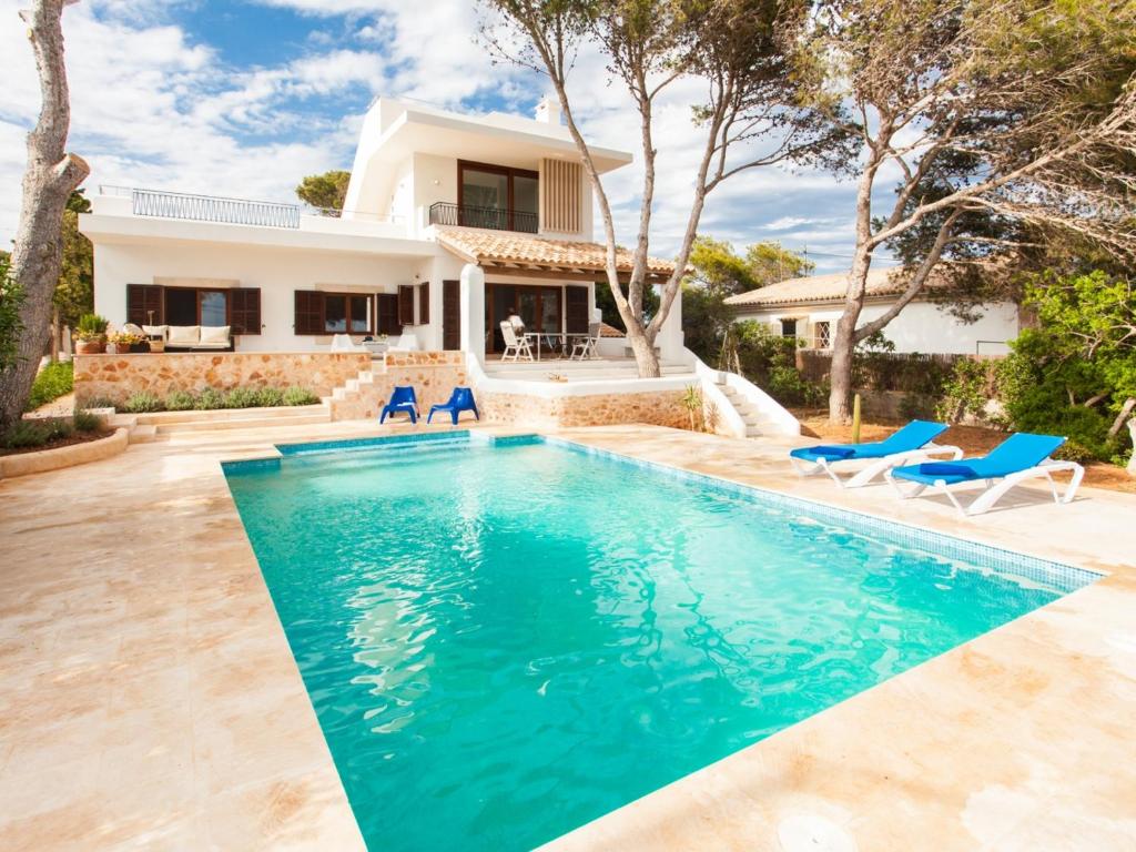 a villa with a swimming pool and a house at Villa Estrella Sea View in Cala Figuera