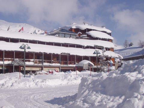 budynek pokryty śniegiem z stosem śniegu w obiekcie Il Fraitevino hotel bed & breakfast w mieście Sestriere