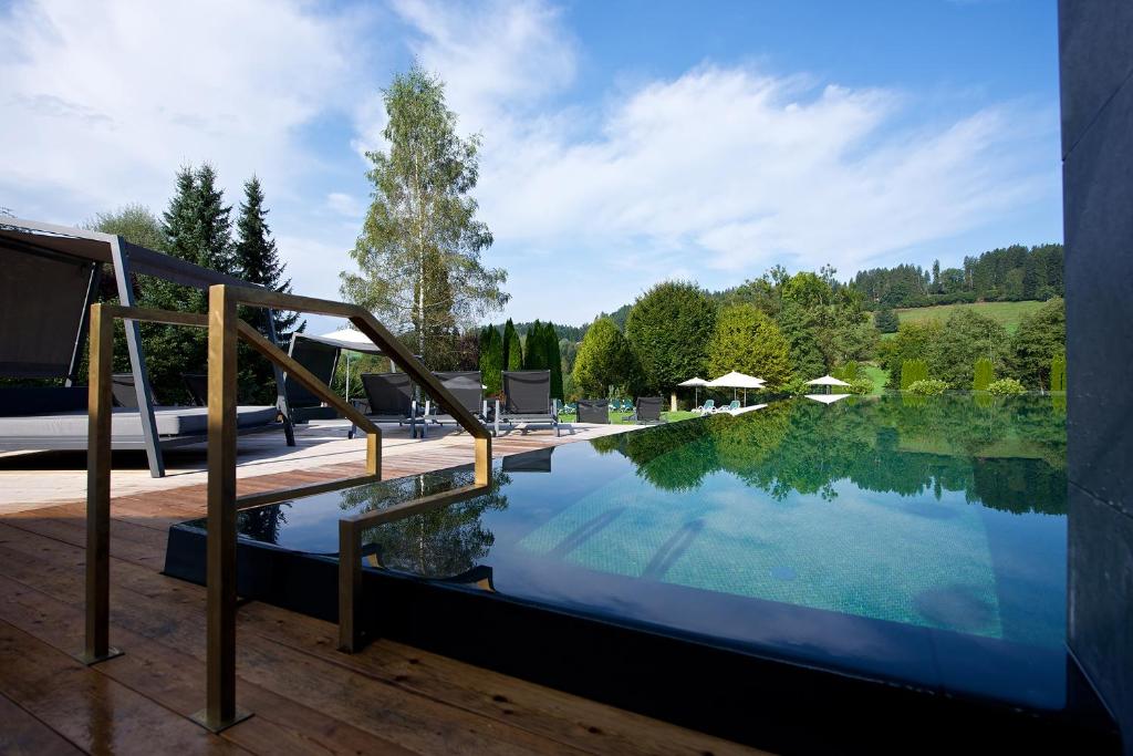 a swimming pool with a staircase leading into a house at Tannenhof Sport & SPA in Weiler-Simmerberg