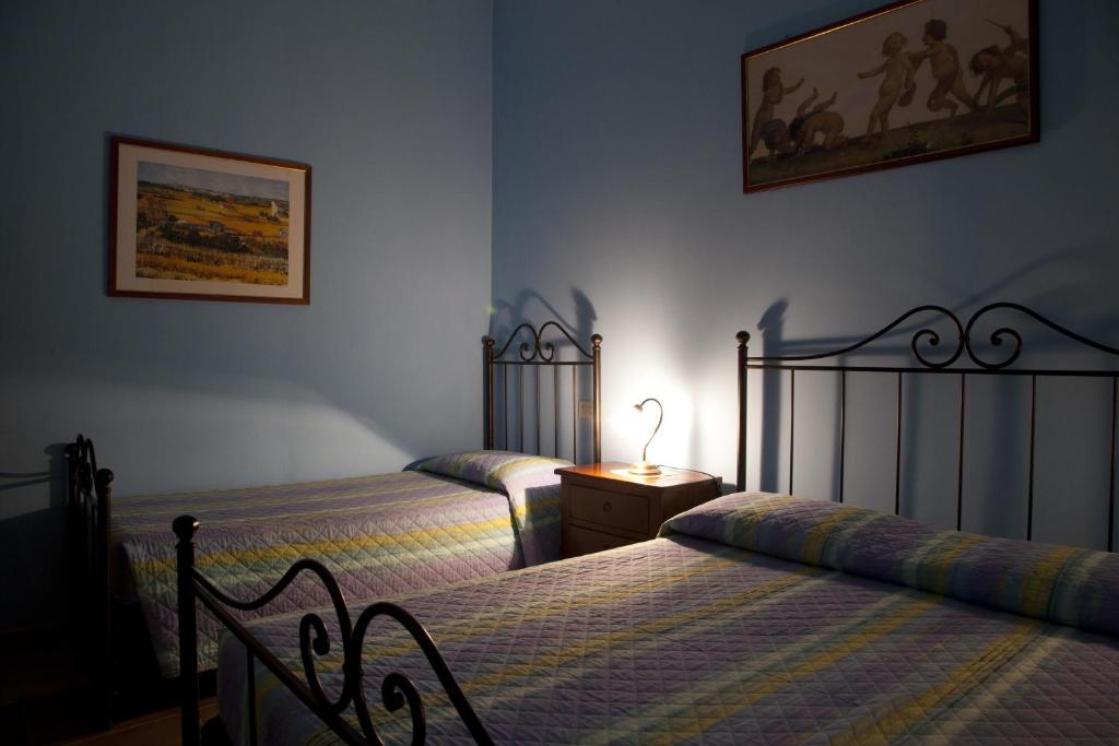 sypialnia z dwoma łóżkami i stołem z lampą w obiekcie Agriturismo San Fedele w mieście Perugia