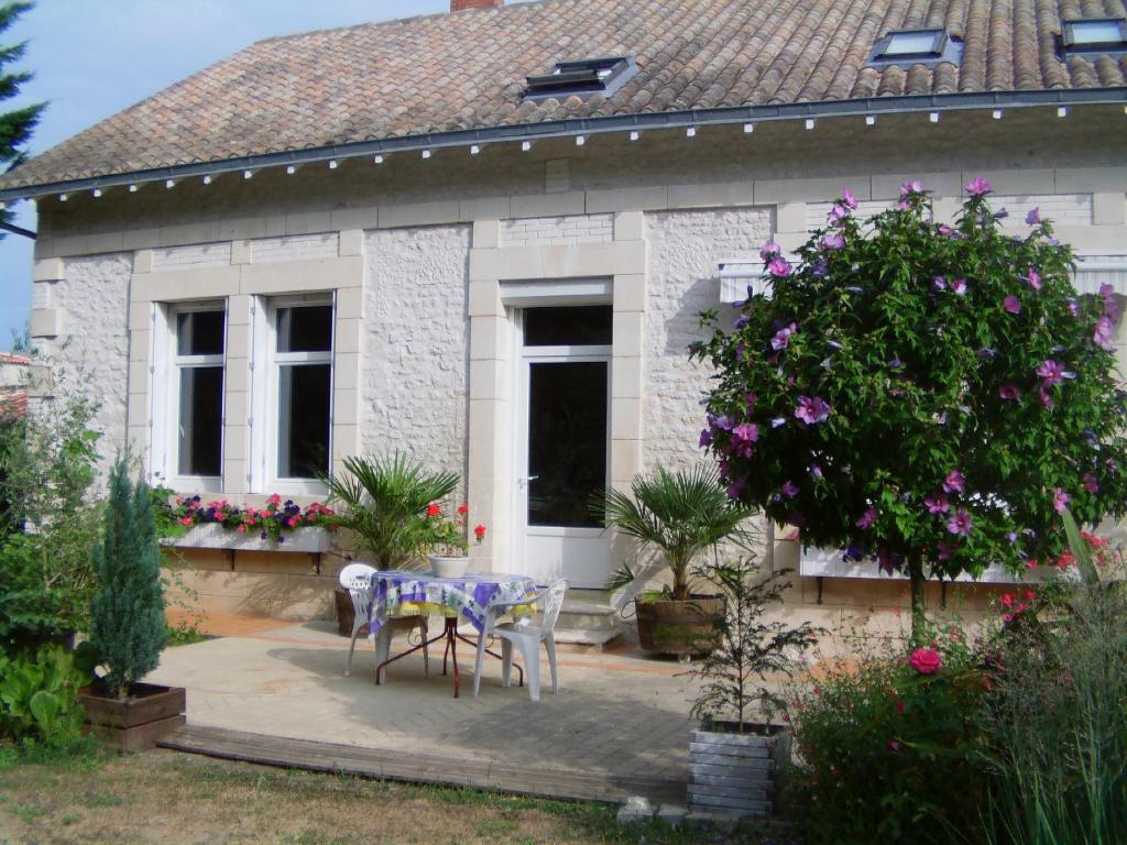 einen Tisch und Stühle vor einem Haus in der Unterkunft B&B Le Chant des Tourterelles - Mr Guieau in Épargnes