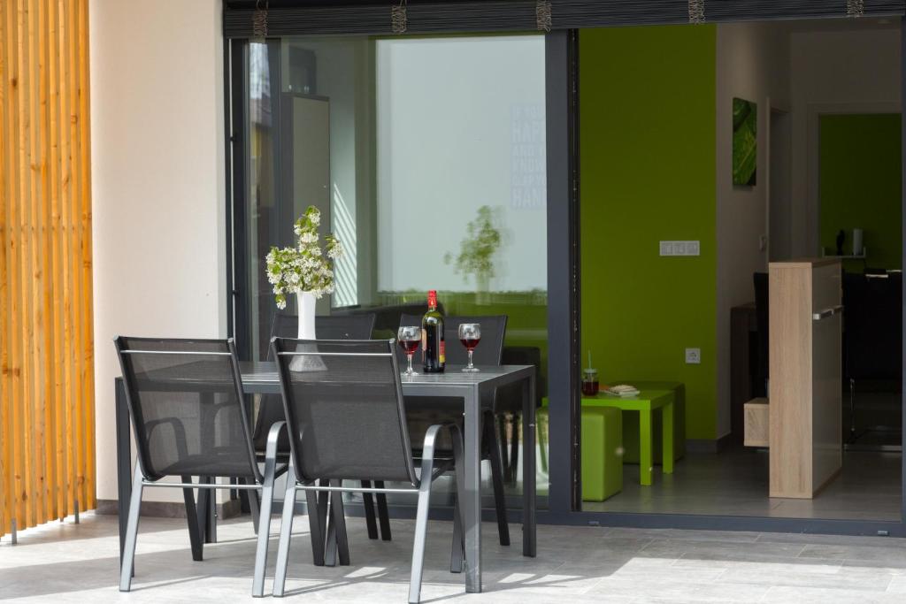 une salle à manger avec une table et des chaises noires dans l'établissement Apartma Mariposa Banovci, à Banovci