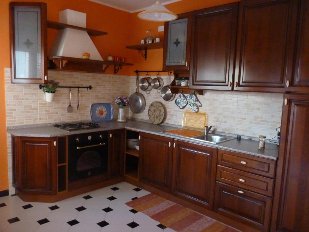 a kitchen with wooden cabinets and a sink and a stove at Il rifugio di Andrea in Giba