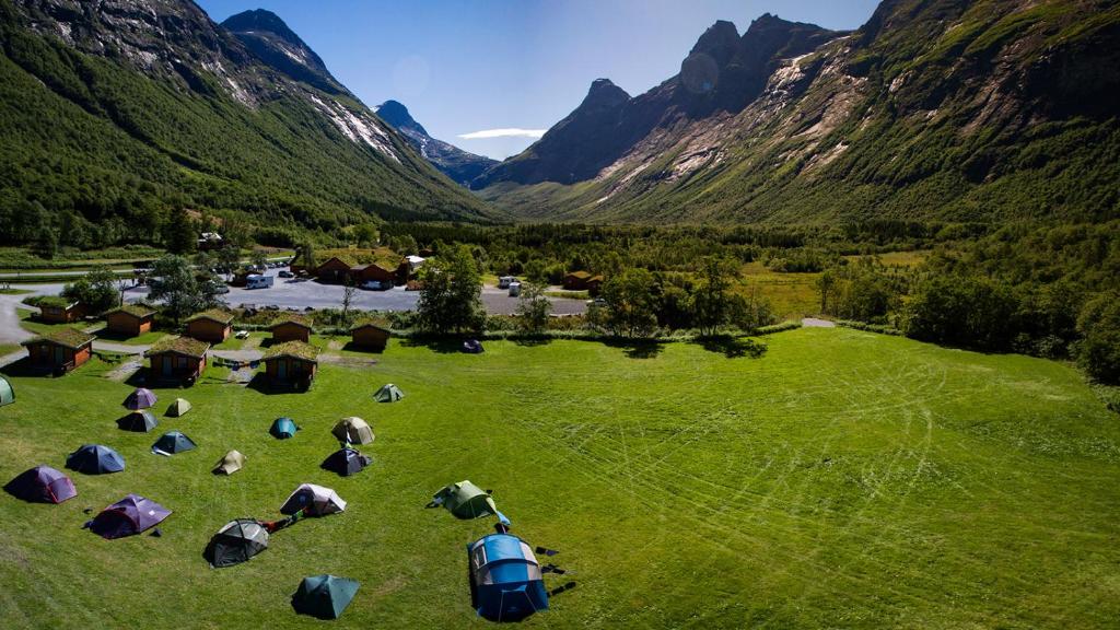 una vista aérea de un campo con tiendas de campaña y montañas en Trollstigen Camping and Gjestegård, en Åndalsnes