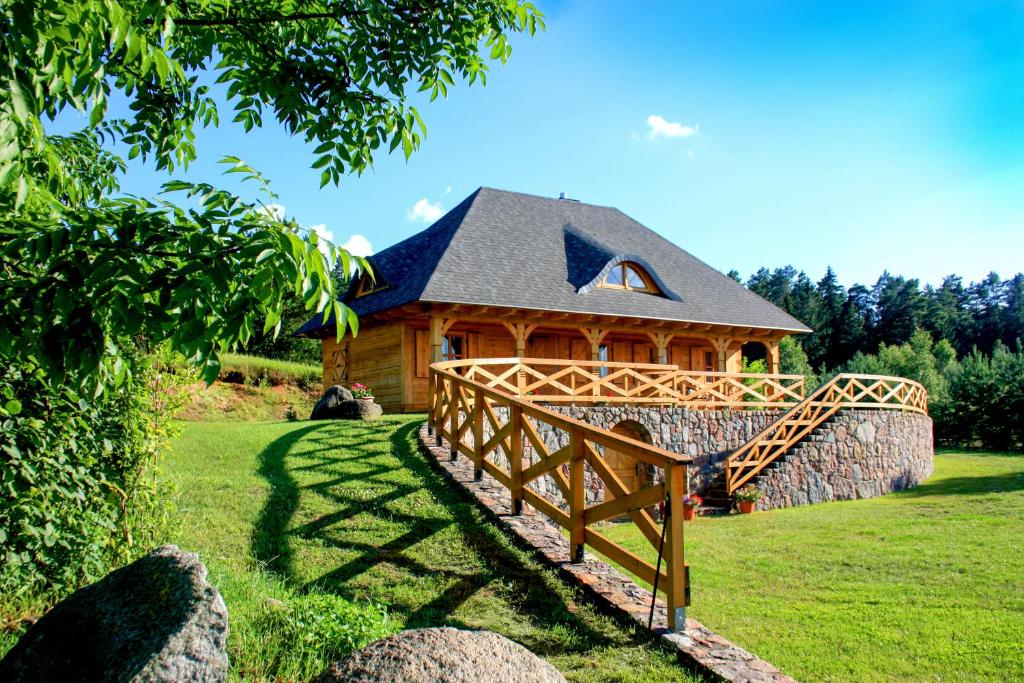 une cabane en rondins avec un pont en bois devant elle dans l'établissement Holiday House Folwark Jeleń, à Poniklica