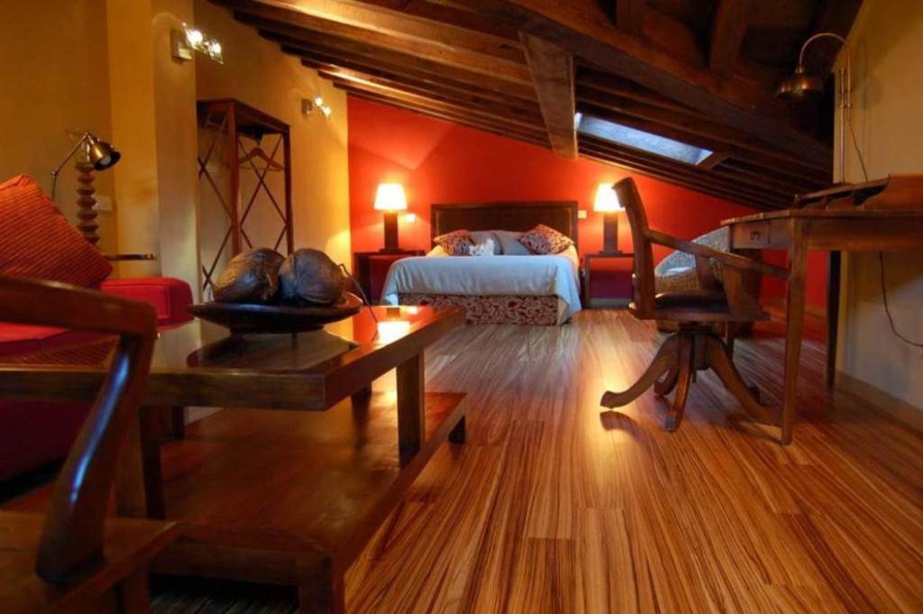 Habitación con 1 dormitorio con 1 cama y 1 mesa. en Estrella rural casa rural en la Sierra de Madrid, en Buitrago del Lozoya