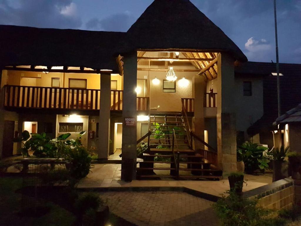 a house with a staircase in front of it at night at Gabbata Lodge in Leeuwfontein