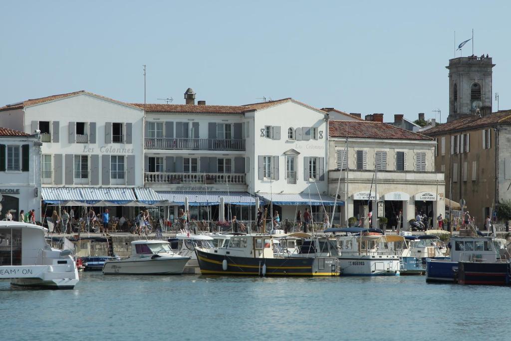 um grupo de barcos ancorados num porto com edifícios em Les Colonnes em Saint-Martin-de-Ré