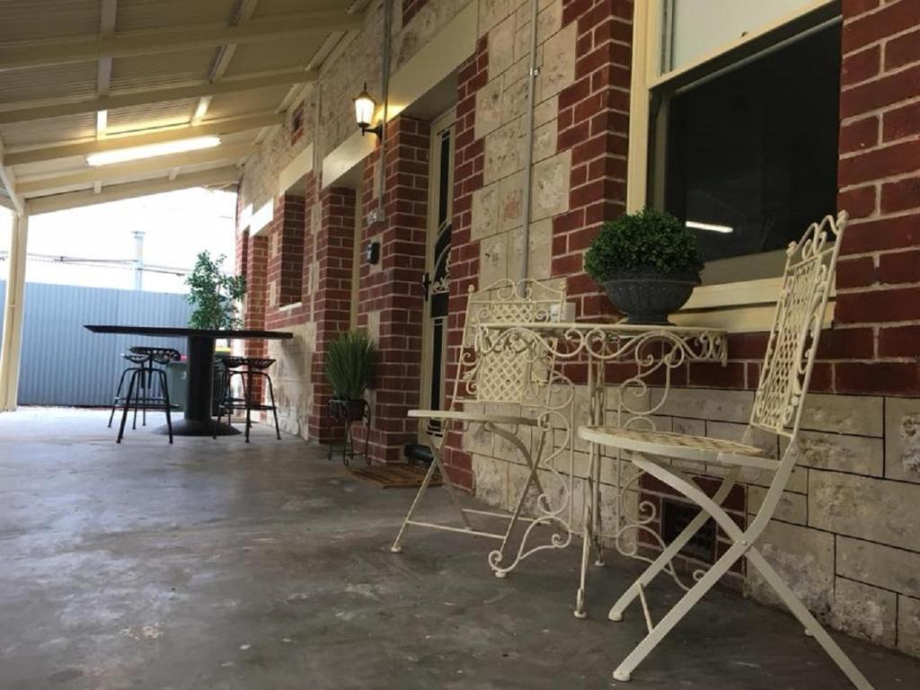 a patio with two chairs and a table and a window at Two Cow Cottage Bed & Breakfast in Keith