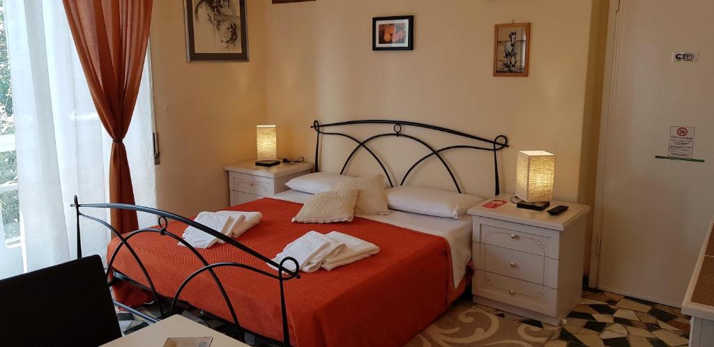 a bedroom with a bed with two night stands and two lamps at Le Midi Versilia in Lido di Camaiore