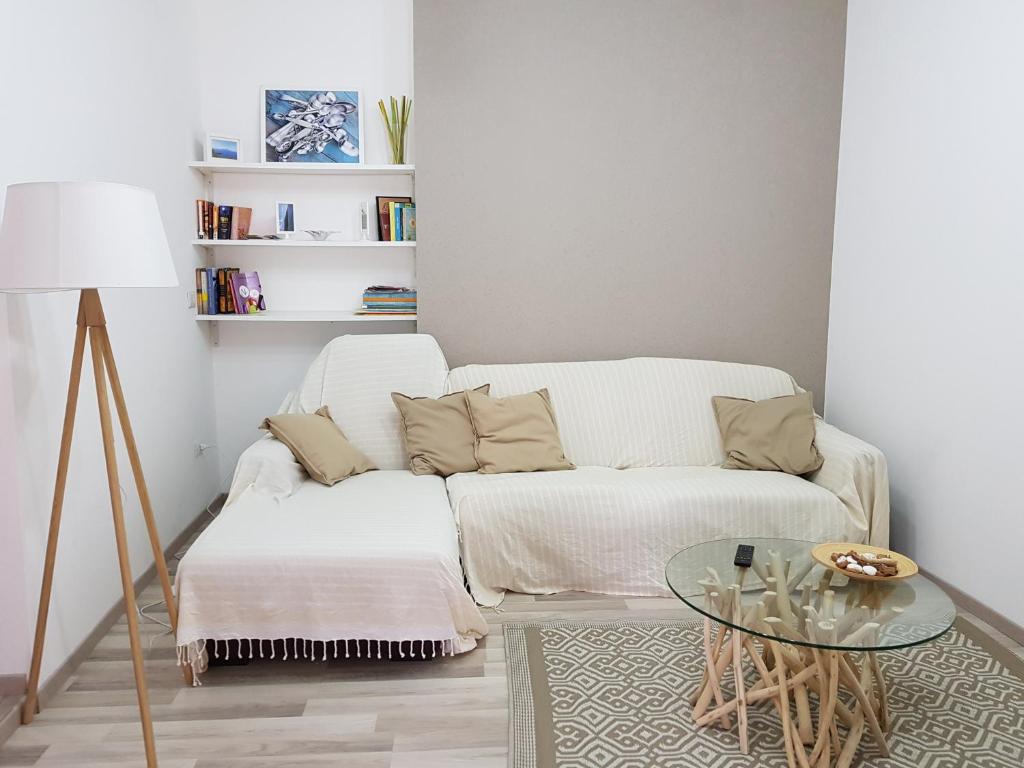 een woonkamer met een witte bank en een glazen tafel bij Jolandahome in Massa Lubrense