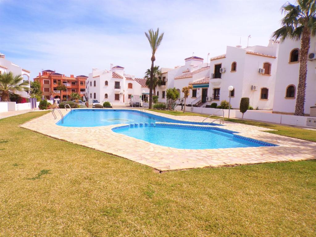 a swimming pool in a yard next to some houses at Villamartin Violetas holiday home in Villamartin
