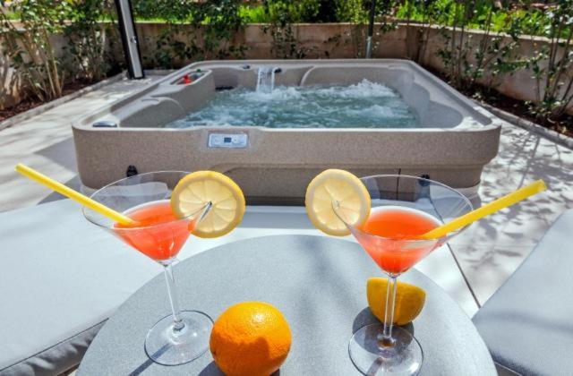 zwei Cocktails auf einem Tisch vor einem Whirlpool in der Unterkunft Villa Augustina in Sukošan