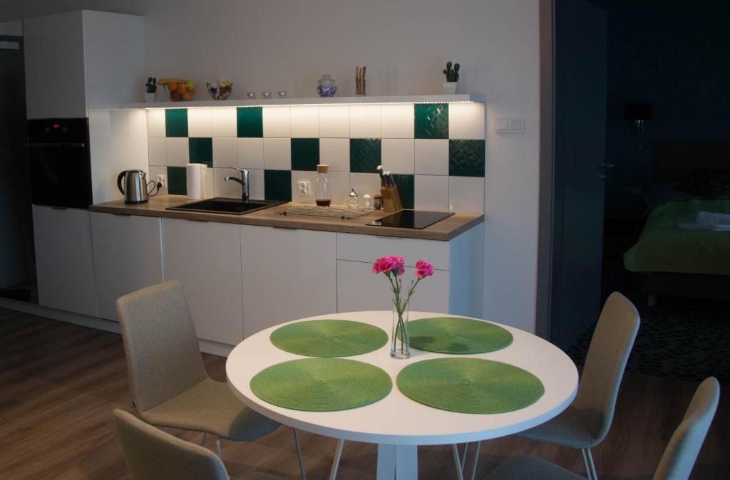 a kitchen with a table with a vase of flowers on it at Apartament 5Mórz Leo in Sianozety