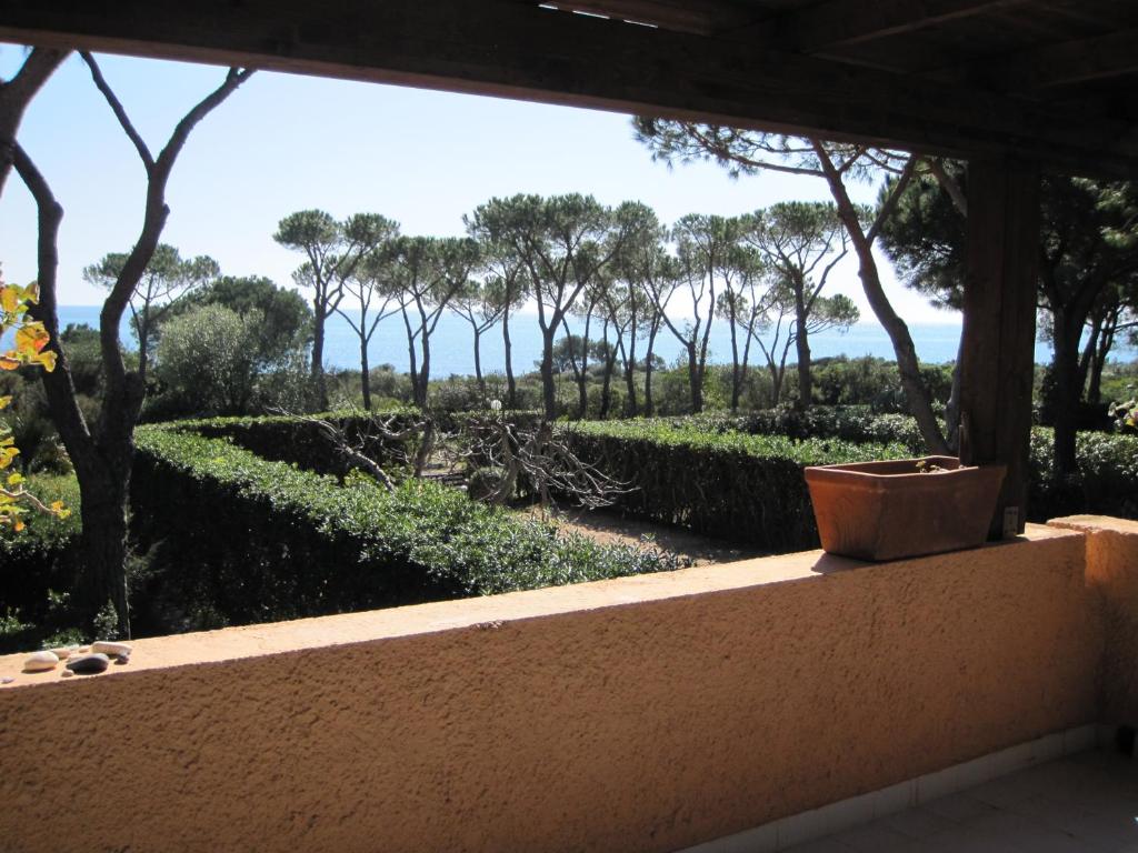 a window view of a garden with a pot on a ledge at Villetta Vista Mare Calaverde IUN Q0265 in Santa Margherita di Pula