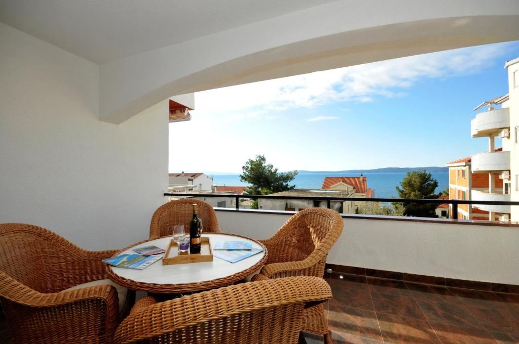 a balcony with a table and chairs and a view at Apartmani Svalina - Seaview and 130m from Beach in Trogir