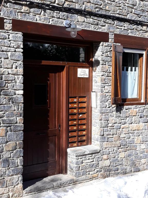 un edificio in mattoni con porta in legno e finestra di Apartament de la Lali Roní a Roní