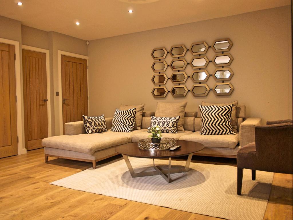 een woonkamer met een bank en een tafel bij The Norfolk Townhouse - Stunning 5BDR Home in Londen