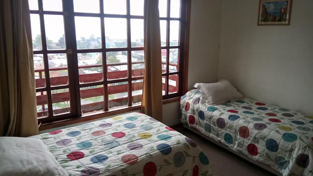 1 dormitorio con 2 camas y ventana con vistas en Habitaciones en Puerto Montt, en Puerto Montt