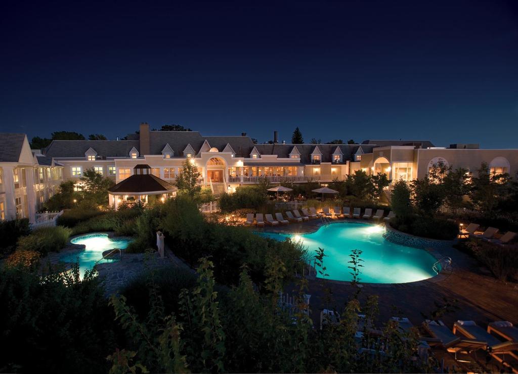 a resort with a swimming pool at night at Hôtel Le Bonne Entente in Quebec City