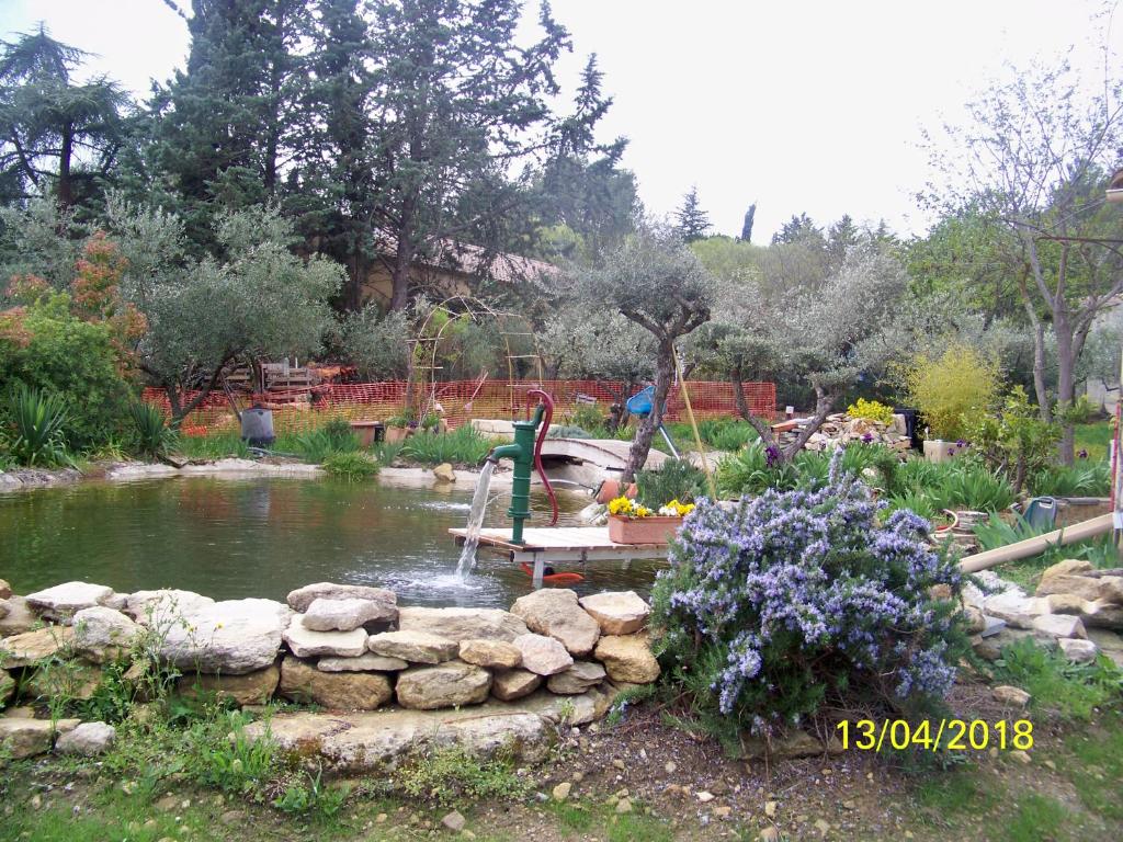 オーベにあるAu Coeur De L Olivetteの池とベンチ、花の庭園