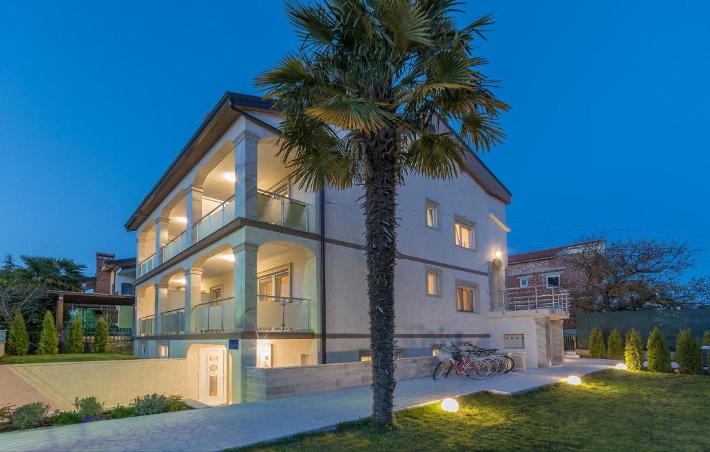 a large house with a palm tree in front of it at Villa Stephany in Poreč