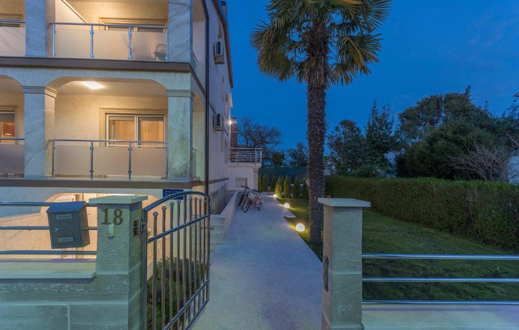 a house with a palm tree next to a sidewalk at Villa Stephany in Poreč