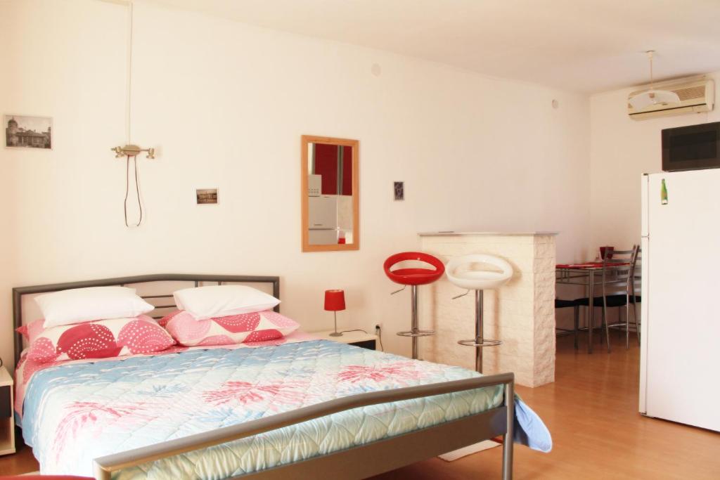 Schlafzimmer mit einem Bett mit rosa und weißen Kissen in der Unterkunft Apartments Tragurion in Trogir