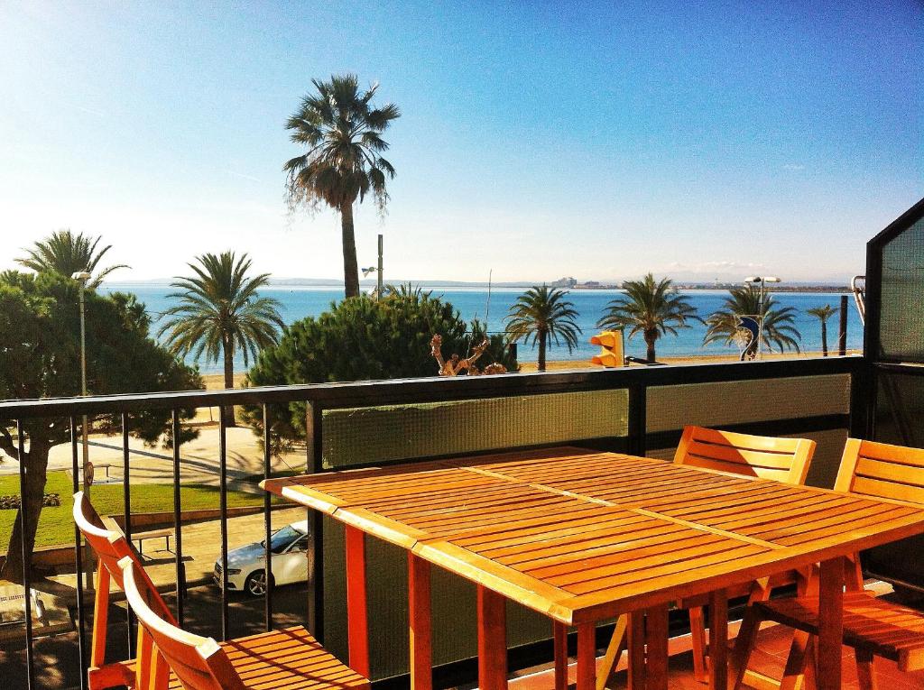 einen Holztisch auf einem Balkon mit Meerblick in der Unterkunft Primera Linea De Mar Centro Roses in Roses