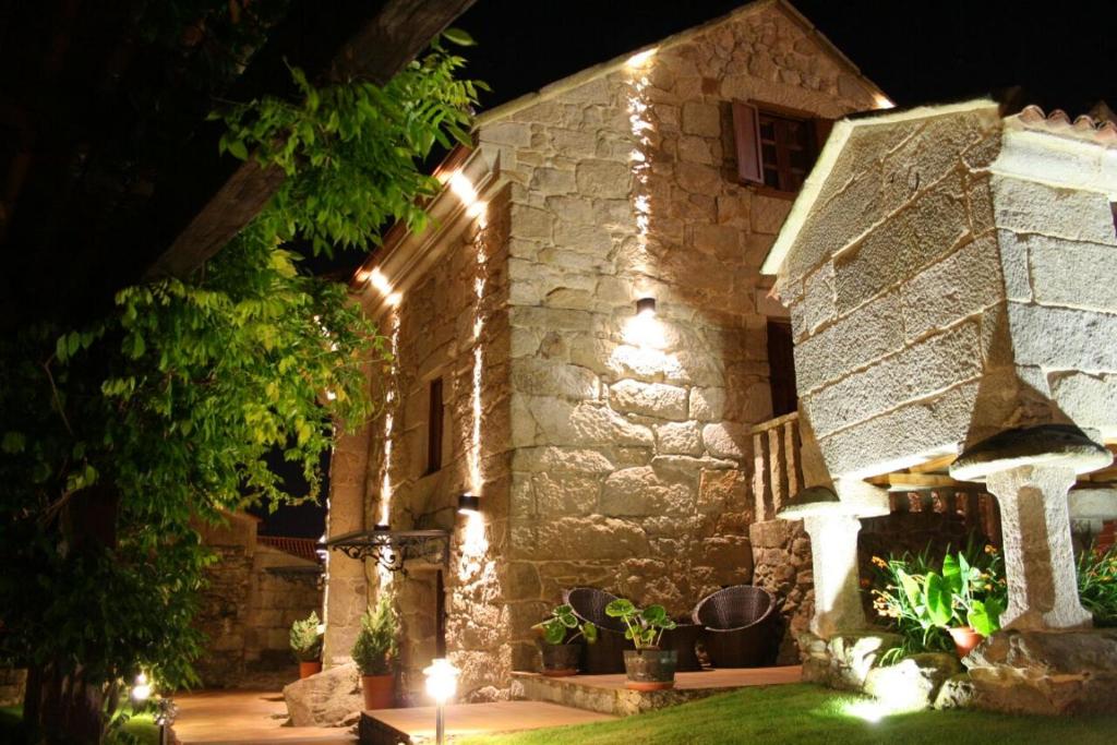 a stone building with lights on it at night at Casa Noelmar in Combarro