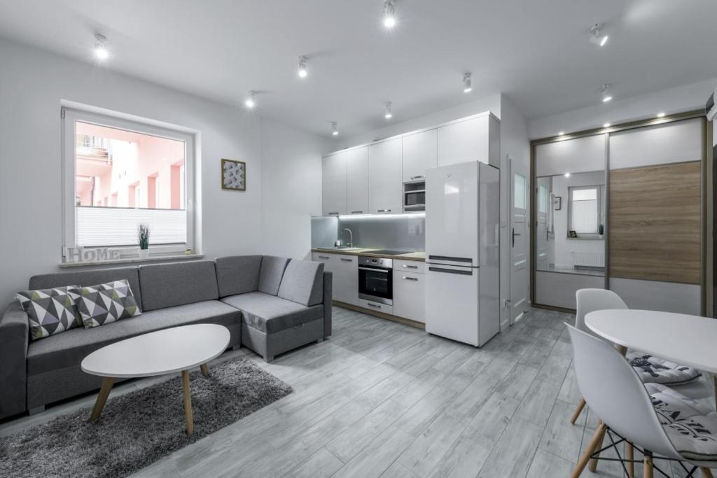 salon z kanapą i kuchnią w obiekcie Apartament Żeglarska U2 w mieście Giżycko
