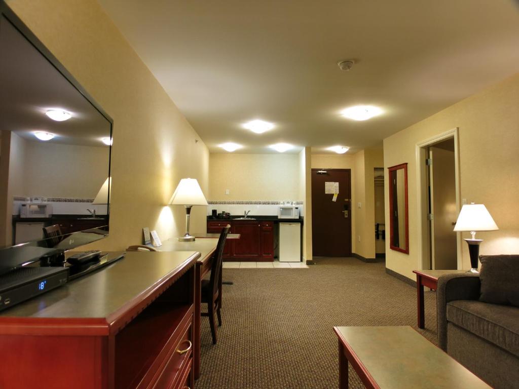 a hotel room with a living room with a couch and a kitchen at Days Inn & Suites by Wyndham Langley in Langley