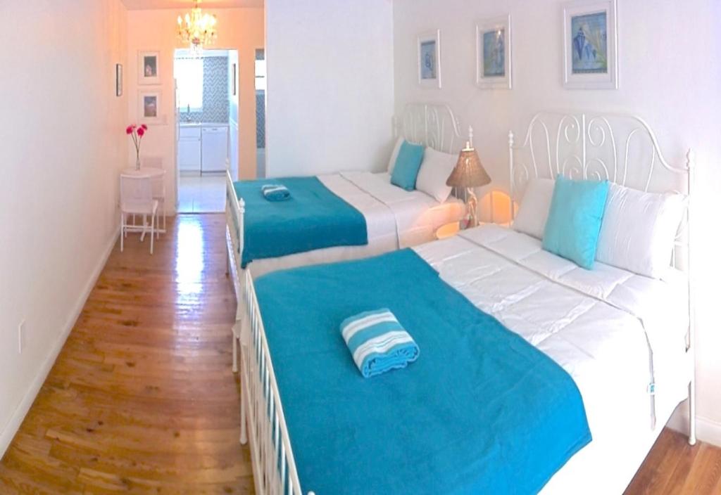 sypialnia z 2 łóżkami w kolorze niebieskim i białym w obiekcie Bikini Lodge w Miami Beach