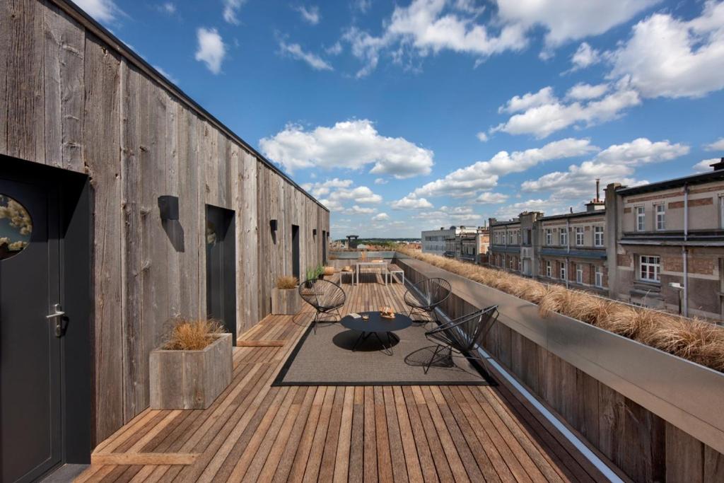 a wooden deck with chairs and a table on a building at Mini Loft ULB DELTA area with terrace in Brussels