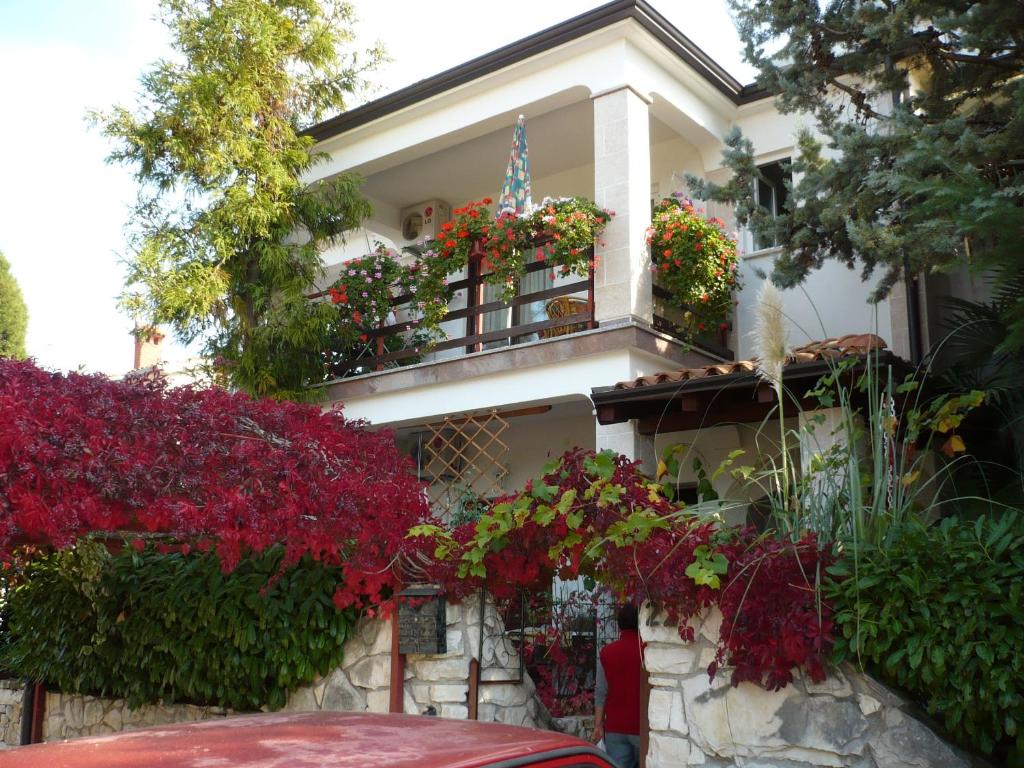 una casa bianca con fiori sul balcone di Apartments Finida a Poreč (Parenzo)