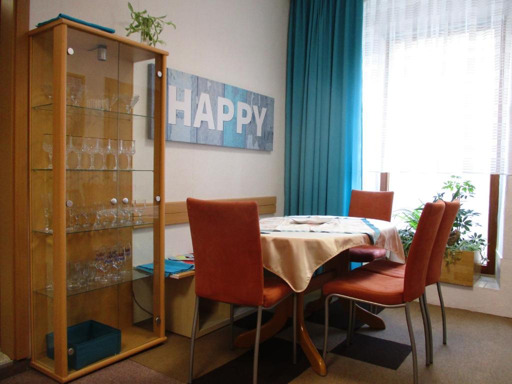 a dining room with a table and chairs and a happy sign at Ferienwohnung Alte Apotheke in Eibenstock