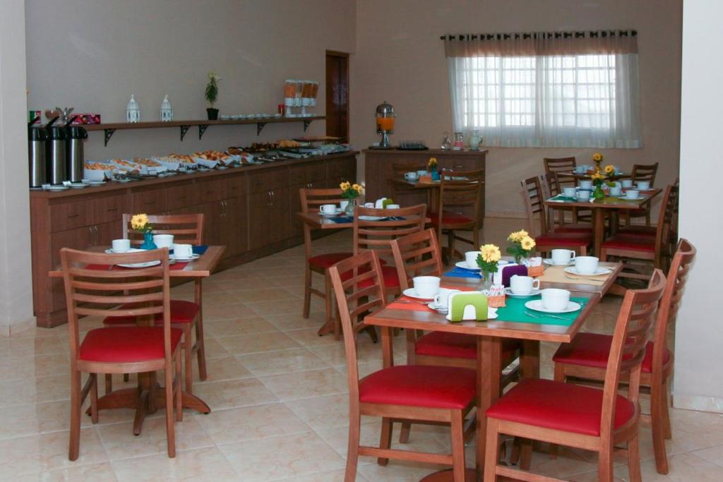 una sala da pranzo con tavoli e sedie in legno di Hotel Fazenda Pirâmides ad Atibaia