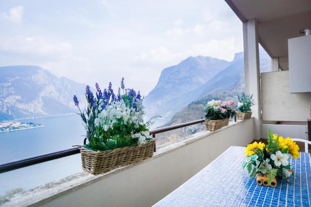 a balcony with flowers and a view of the water at Angolo Paradiso - Lago di Como in Valbrona