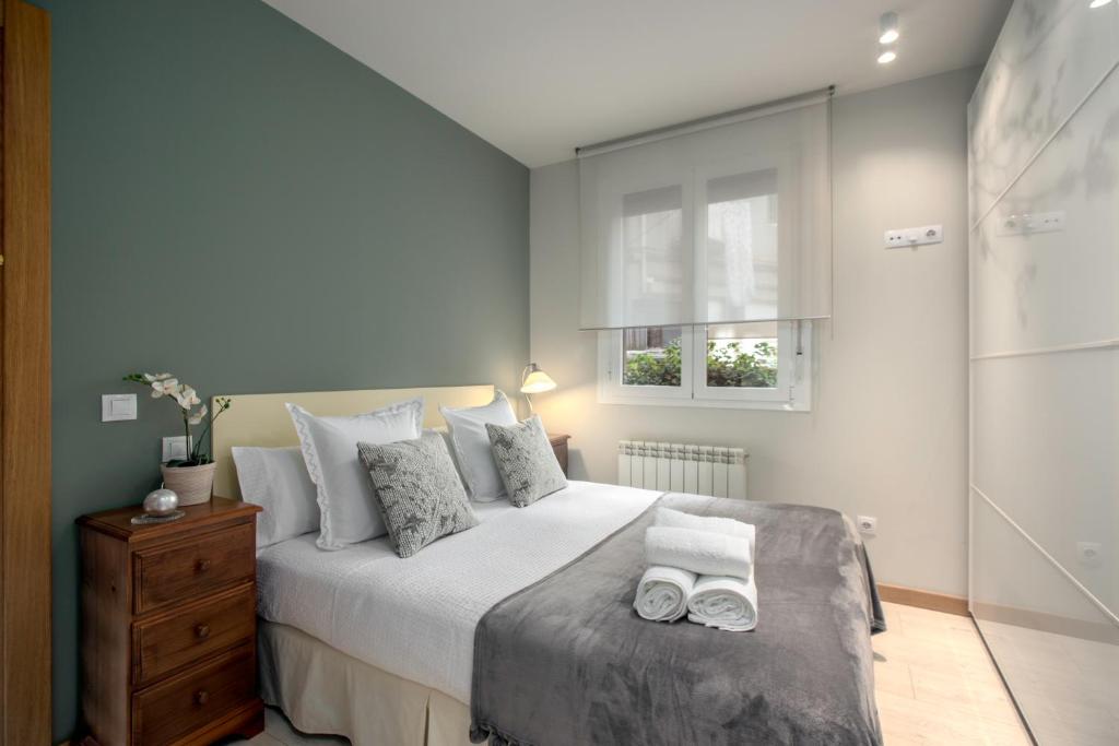 ein Schlafzimmer mit einem Bett mit zwei Handtüchern darauf in der Unterkunft Ondarreta Beach Apartment con parking free y Aire acondicionado in San Sebastián