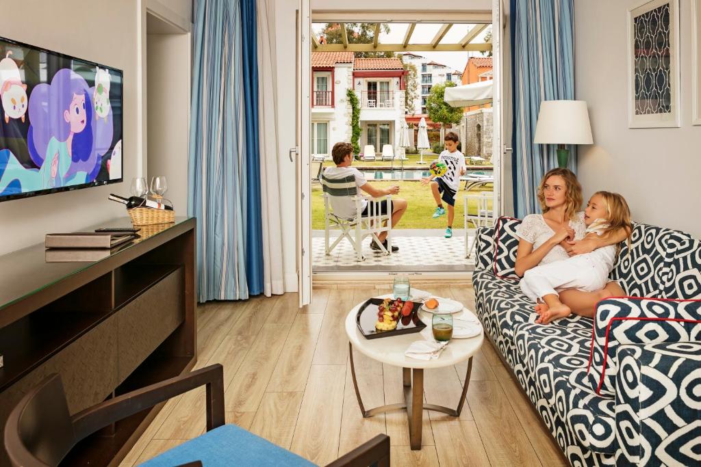 a mother and daughter sitting on a couch in a living room at IC Hotels Santai Family Resort - Kids Concept in Belek